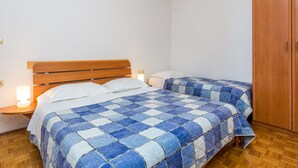 Un dormitorio con dos camas, cabeceros de madera y un armario.