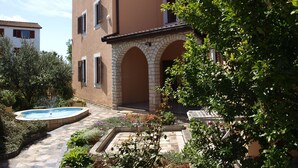 A building with a courtyard, a swimming pool, and a garden with various plants. - Appartement in Fažana mit Möbliertem Balkon by Interhome (Fažana)