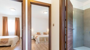 A hotel room with a wooden door leading to a bathroom and a bedroom. - Modernes Apartment mit Balkon und Gemeinschaftsgarten am Waldrand by Interhome (Dracevac)