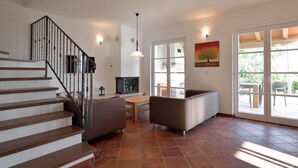A spacious living area with a staircase, a sofa, a dining table, and a TV. - Villa Miramar by Interhome (Poreč/Tar)