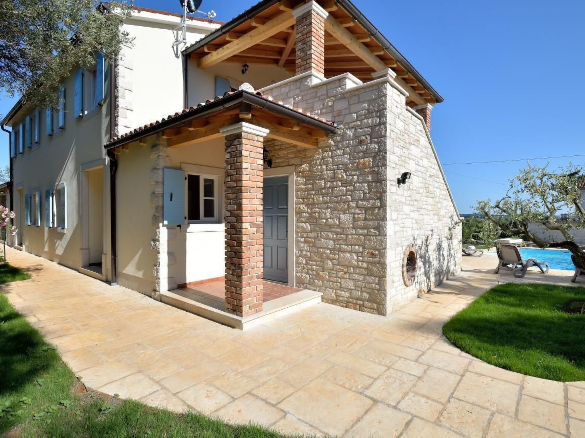 A two-story house with a stone exterior and a tiled roof.