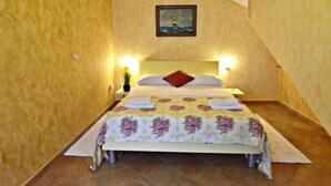 A bedroom with a bed, a nightstand, a lamp, and a painting on the wall. - FIORELA 1 by Interhome (Poreč/Tar)