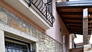 A stone building with a window and a set of wooden stairs leading to a covered area. - Apartment Noemi2 by Interhome (Poreč/Tar)