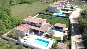 Una propiedad residencial con piscina, varias casas y un jardín bien cuidado.
