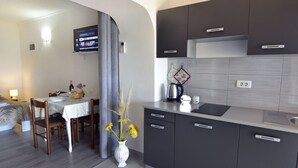 A modern kitchen with grey cabinets, a white countertop, and a dining area with a table set for two. - Appartement in Zambratija mit Schöner Terrasse by Interhome (Umag/Zambratija)