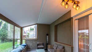 Una sala de estar moderna con un ventanal grande, una chimenea y un área de descanso con cojines.