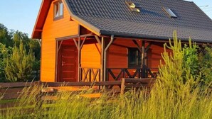 A wooden cabin with a sloped roof, a front porch, and a small window. - "Eko Domek" mit eigener Terrasse by Interhome (Junoszyno)