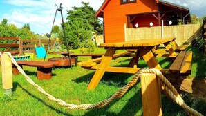 Puinen rakenne, jossa on korotettu alusta ja aidattu alue, mahdollisesti leikkialue tai teemaan liittyvä nähtävyys.