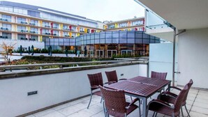 A terrace with a table and chairs, a modern building in the background, and a clear sky. - mit Wasserblick by Interhome (Kolobrzeg)