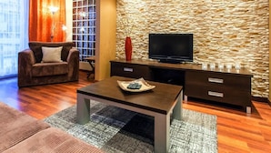 A modern living room with a stone wall, a flat-screen TV, a sofa, and a coffee table. - mit Wasserblick by Interhome (Kolobrzeg)