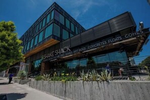 A modern building with a sign for 'Shake Shack' and 'Hot Dogs, Fries, Shakes, Burgers, Pretzel Pretzels, and More.'