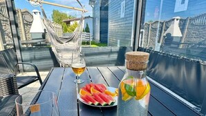 Ett bord med ett glas öl, en flaska vatten med frukt i och en tallrik med skivor av vattenmelon.
