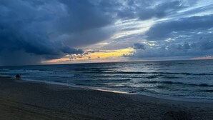 Uma praia com vista para o oceano e um céu nublado.