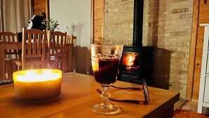 Um quarto aconchegante com uma mesa de madeira, uma vela acesa e um copo de vinho tinto.