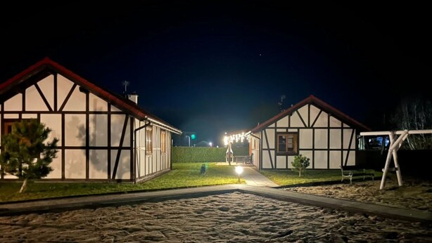 Uma passagem que leva a edifícios tradicionais em enxaimel, durante a noite.