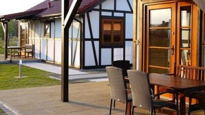 Um edifício tradicional em enxaimel com uma mesa e cadeiras de madeira na varanda.