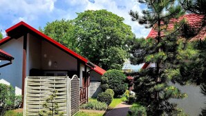A residential building with a red roof, a wooden fence, and a pathway leading to the entrance. - Beach Club-Häuser direkt am Strand by Interhome (Dziwnówek)