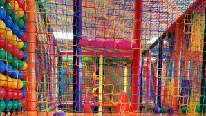 A multi-level indoor play area with netted climbing structures and a ball pit. - Beach Club-Häuser direkt am Strand by Interhome (Dziwnówek)