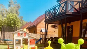 A children's play area with colorful play structures and a small house in the background. - Appartements mit einem Wohn-,Ess- und Schlafraum und kleinem Balkon für vier Pe by Interhome (Niechorze)
