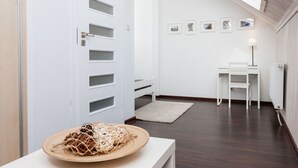 A modern room with a skylight, a white door with multiple panels, a small table with a woven basket, a white desk, and a chair. - "Kapitanski" mit Schwimmbad by Interhome (Rewal)