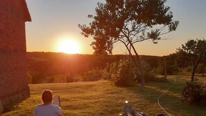 Due persone sedute su delle sedie a sdraio che guardano il tramonto.