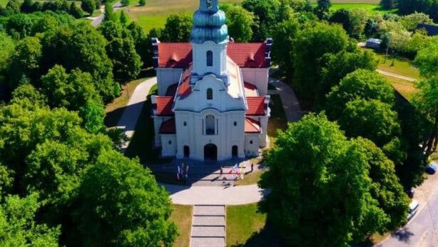 Una vista aerea di una chiesa circondata da vegetazione lussureggiante.
