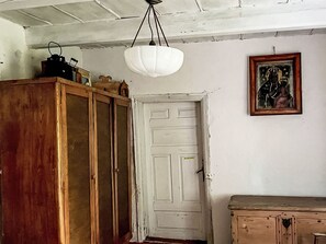 Una habitación con un armario de madera, una puerta blanca y un cuadro en la pared.