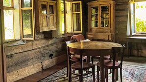 A rustic wooden interior with a round table and chairs, wooden cabinets, and a window with curtains. - unter der Linde by Interhome (Krzyszkowice)