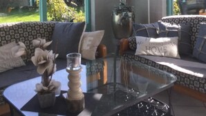 A modern living room with a glass coffee table, a sofa with patterned cushions, and a decorative vase. - in Dirkshorn by Interhome (Dirkshorn)