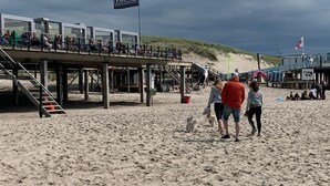 A beach with a wooden pier, a lifeguard tower, and a flag. - in Dirkshorn by Interhome (Dirkshorn)