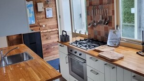 Una cocina moderna con encimera de madera, electrodomésticos de acero inoxidable y vistas al exterior.