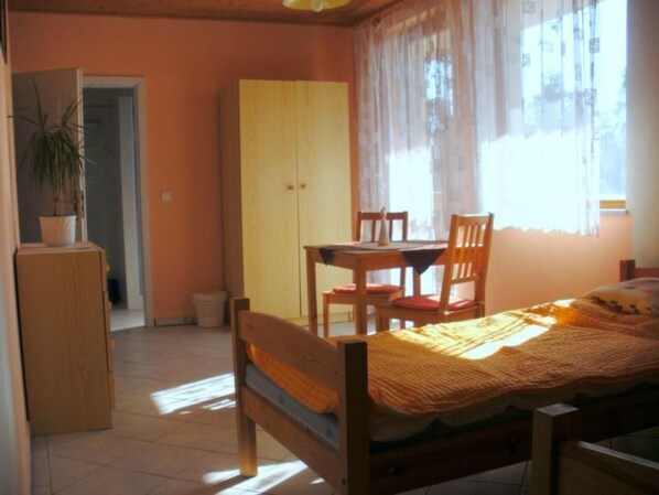 A bedroom with a bed, a wooden desk, a chair, a wardrobe, and a potted plant. - Villa Regina by Interhome (Sebestenice)