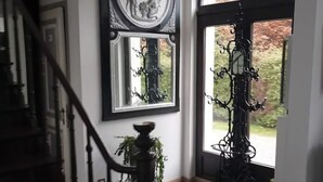 Eine Treppe führt zu einer Empore mit einem großen Fenster und einer Tür mit schmiedeeisernem Gitter.