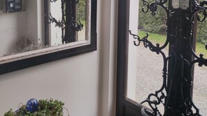 Ein Zimmer mit großem Fenster, schmiedeeisernem Gitter und einer Wanddekoration.