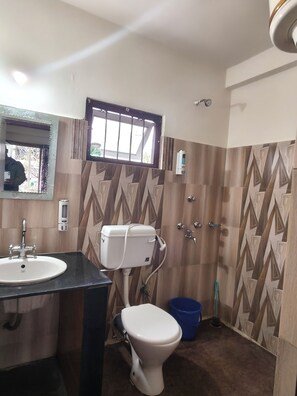Un baño con inodoro, lavamanos y ducha.