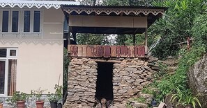 A stone archway leading to a covered outdoor area with a wooden bench.