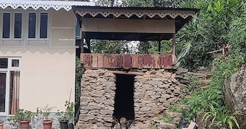 Un arco de piedra que da paso a una zona exterior cubierta con un banco de madera.
