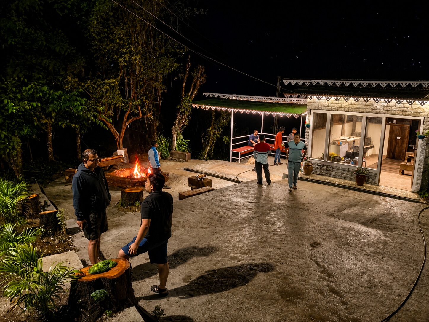 An outdoor area with a fire pit, seating, and a building with a glass door.