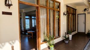 Un vestíbulo con una ventana de madera, un letrero que dice 'LOBBY' y plantas en macetas.