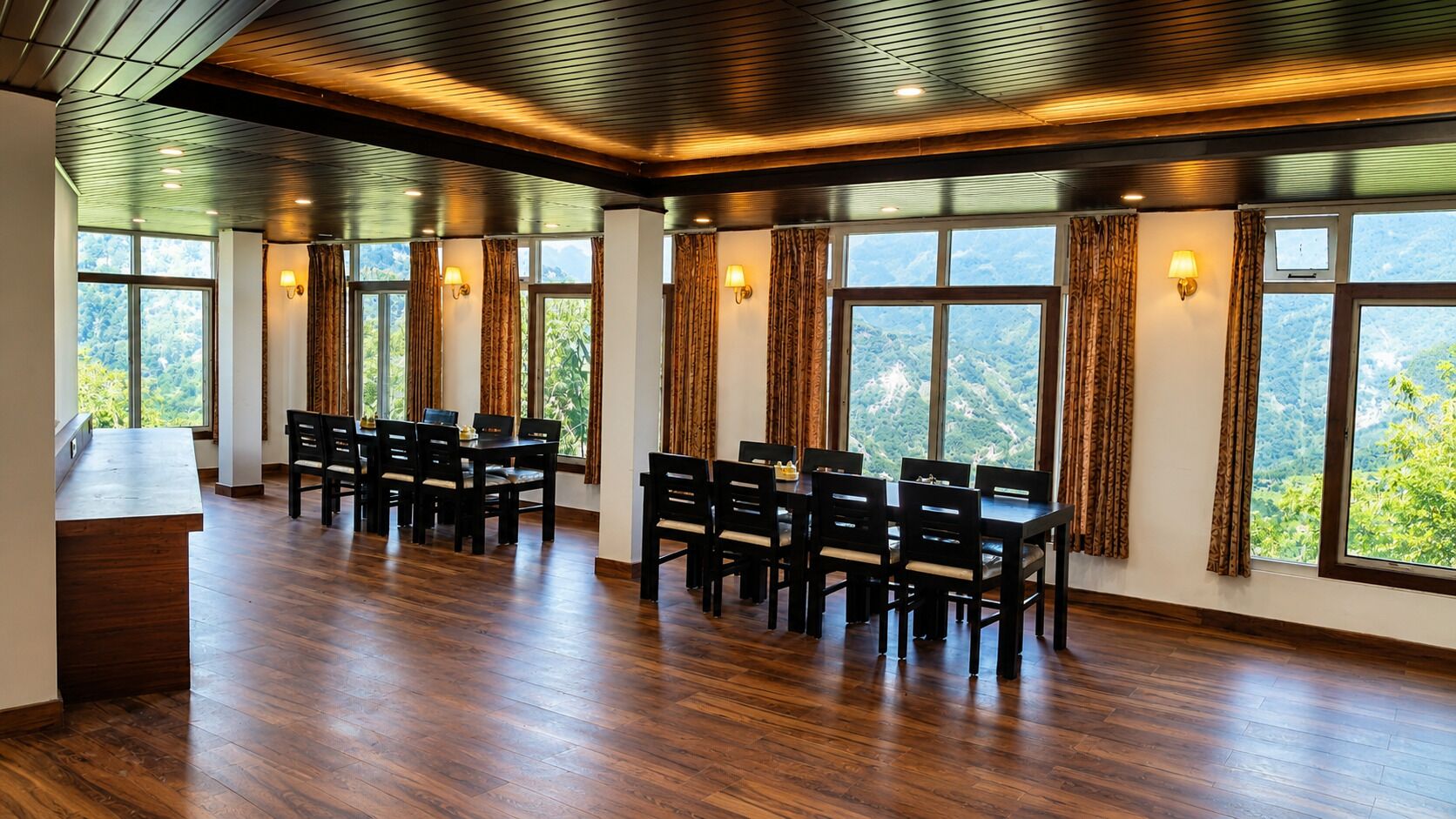 A spacious room with a wooden floor, large windows with curtains, and a table with chairs.