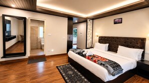 A bedroom with a large bed, a mirror, a nightstand, and a view of the bathroom.