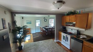 A kitchen with wooden cabinets, a stove, and a refrigerator. - Comfortable 2-bedroom house in Boise. Hot Tub. Fenced yard. Pet friendly. (Boise)