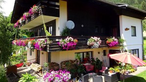 Een gebouw met twee verdiepingen, voorzien van een balkon met bloembakken.