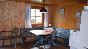Un interior de madera con una mesa, bancos y sillas de madera.