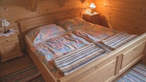 A wooden room with a bed, nightstand, and lamp. - Holzhaus Klippitzblickhütte by Interhome (Bad St. Leonhard im Lavanttal)