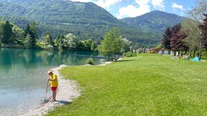 A grassy area with a lake, trees, and mountains in the background. - Apartment Ahorn by Interhome (Feistritz im Rosental)