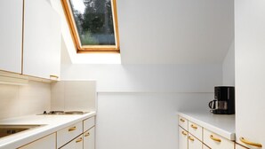 A kitchen with white cabinets, a skylight, and a coffee maker. - Erle in Feistritz im Rosental by Interhome (Feistritz im Rosental)