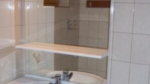 A bathroom with two sinks, a mirror, and a towel rack. - Typ 3 im Haus Huber in Bleiburg by Interhome (Bleiburg)