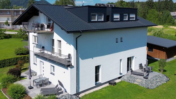 A modern two-story house with a balcony, a patio with outdoor furniture, and a well-maintained lawn. - Appartement in Unterburg Am Klopeiner See by Interhome (Klopeiner See)