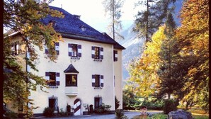 Ein großes, zweistöckiges Gebäude mit einer symmetrischen Fassade, zahlreichen Fenstern mit Fensterläden und einem zentralen Eingang.